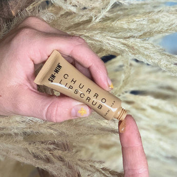 SIN-MIN Churro Lip Scrub being dispensed onto the finger. 