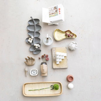 Interlocking Marble Book Holder holding a book on a tablescape styled with unique shaped dishes, vases and dried florals.