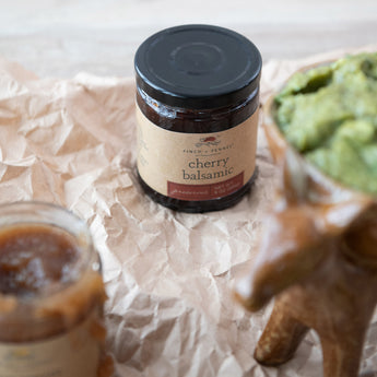 Cherry Balsamic Preserves on top of parchment paper with other condiments. 