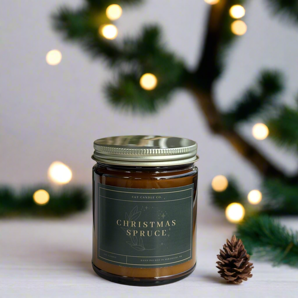 Christmas Spruce scented soy wax candle in an amber glass jar with gold metal lid. 