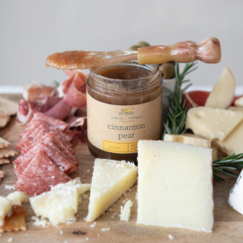 Cinnamon Pear Jam in middle of a charcuterie board with meats and cheeses. 