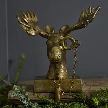 Woodland Holiday decoration of a gold finished antique brass stocking holder, a moose named Eugene. 