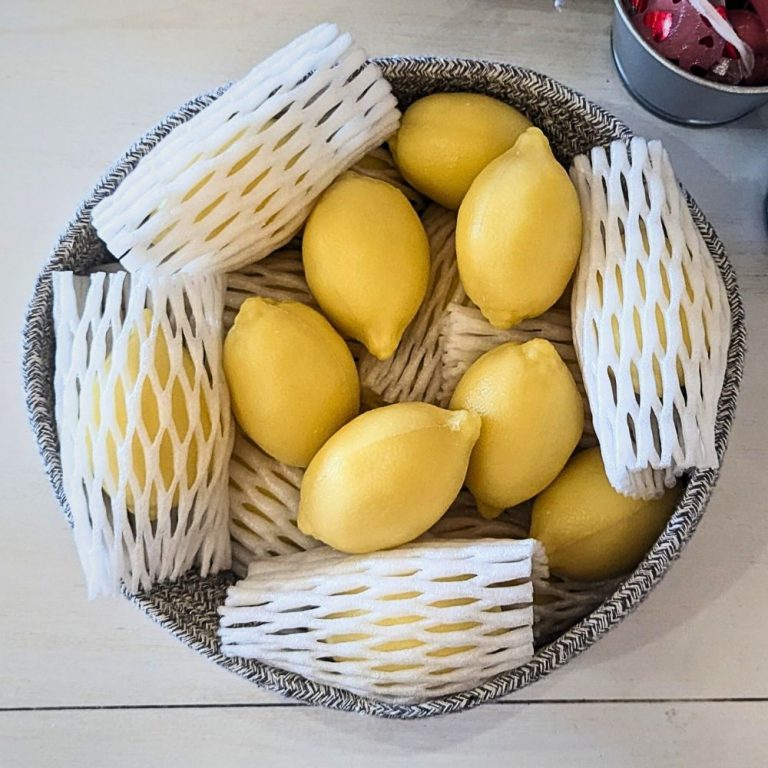 A bowl of Marseille Lemon Shape Soap Bars on the kitchen counter, resembling real lemons. 