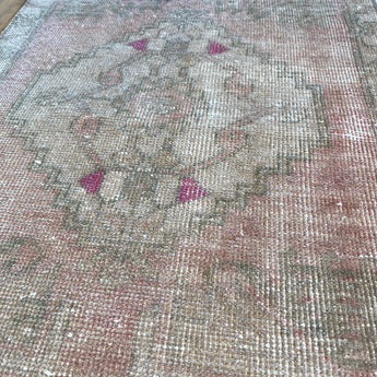 Pale pink rug with fuchsia accents. 