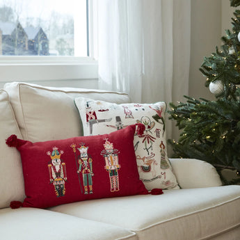 Nutcracker Pillow styled on a couch next to a Christmas tree. 