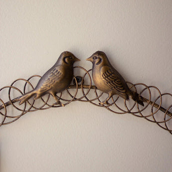 Close up view of the two birds on the christmas card wreath. 