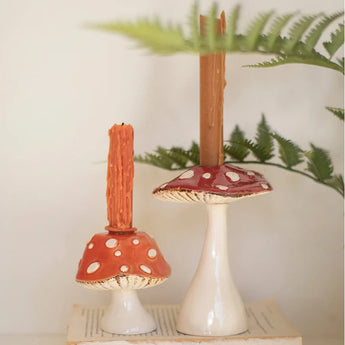 Ceramic Toadstool Taper Holders on top of vintage books.