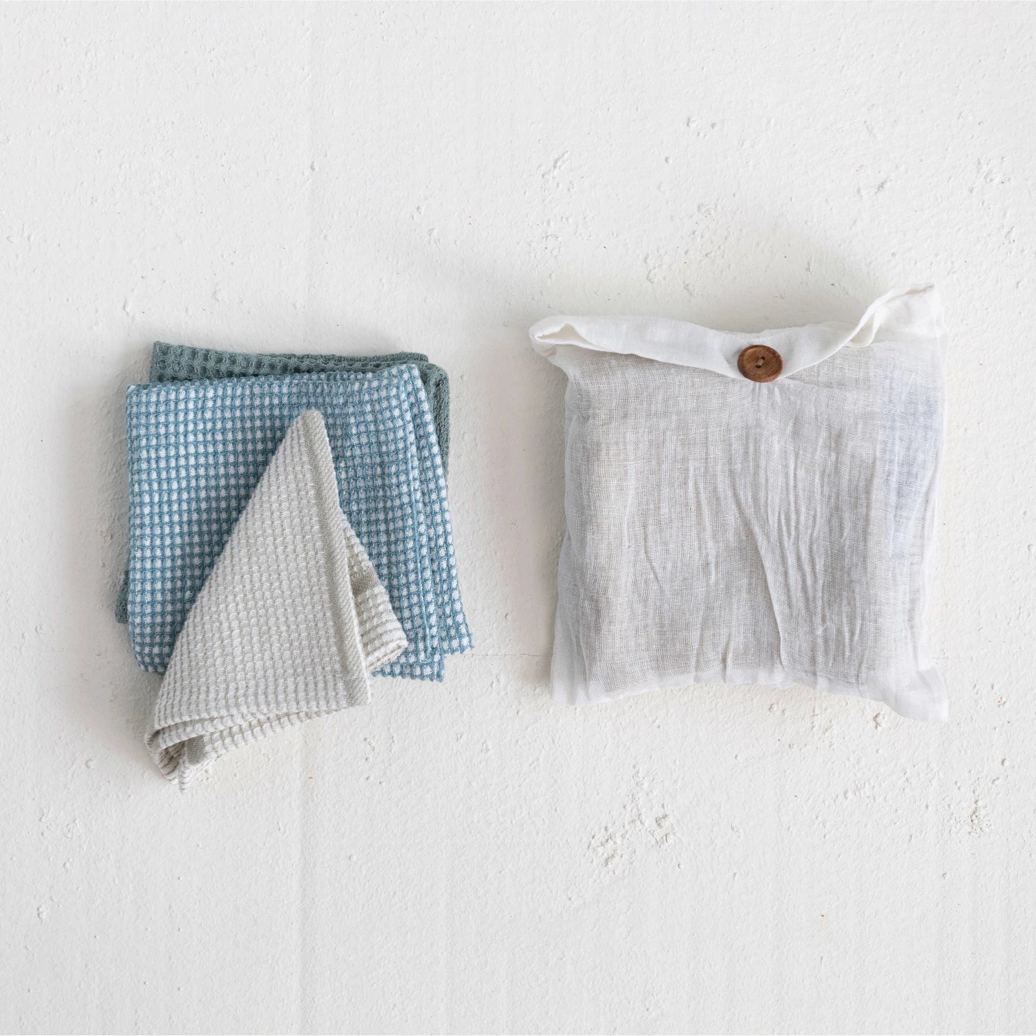 Folded Dish towels pictured beside cotton bag that set comes in