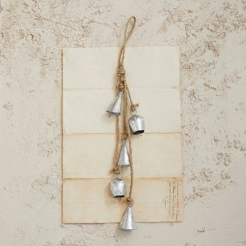 Handmade Hanging Metal Bells with Jute Rope on a piece of antique paper. 