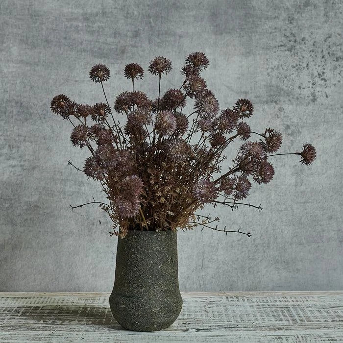 Meadow flower melaleuca purple stems in clay vase.