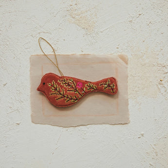 Cotton Velvet Bird Ornament with Glass Beads & Embroidery laying on a piece of paper.