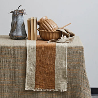 Cotton & Linen Table Runner with Stripe & Fringe styled on top of a table with decor. 