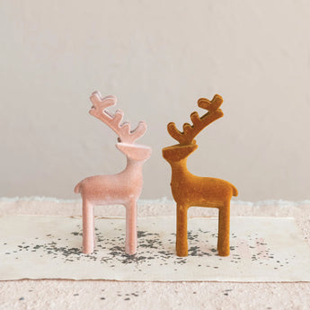 Two styles of flocked plastic reindeer in amber and blush colors. 