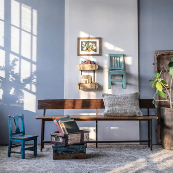 Vintage green chair mounted on the wall as decor and a bright blue chair on the floor in a playroom. 