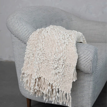 Woven Cotton Blend Cable Knit Throw with Fringe thrown over side of chair.