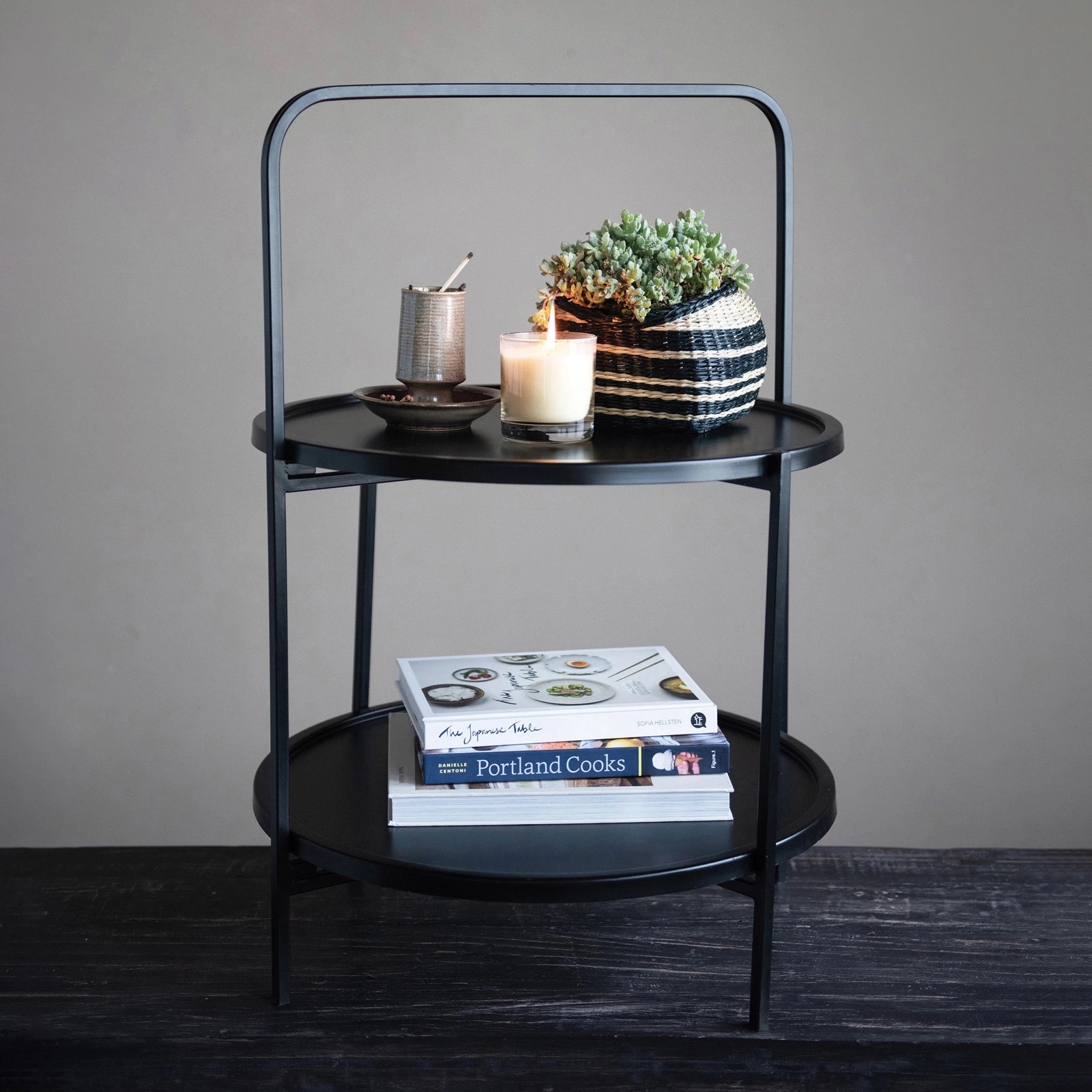 Stoneware Match Holder with Striker Plate on a side table with a candle burning and a potted plant. 